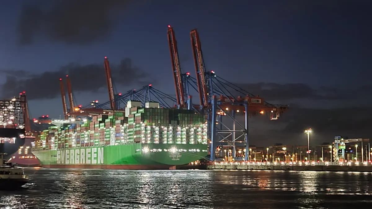 Beleuchtetes Containerschiff im Hamburger Hafen bei Nacht